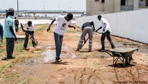 Cleaning the flooded ground in order to paint the wall. 